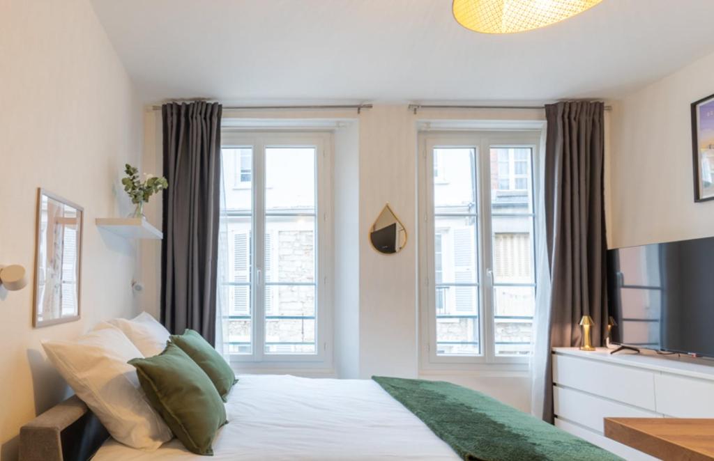 枫丹白露Cœur de Fontainebleau: Confort, Calme & Haut débit的一间卧室设有一张床和两个窗户。