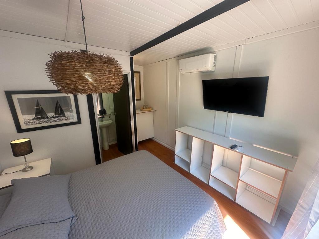 埃斯特角城Posada Guasu的一间卧室配有一张床和一台平面电视