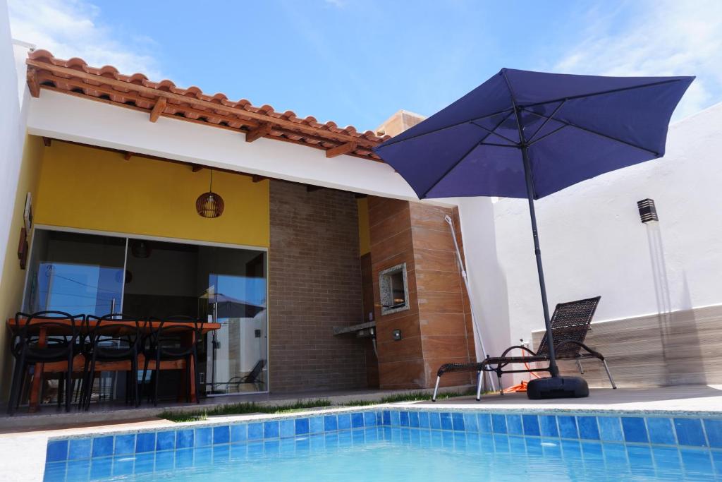 普拉杜ESTRELA DO MAR的游泳池旁的蓝伞