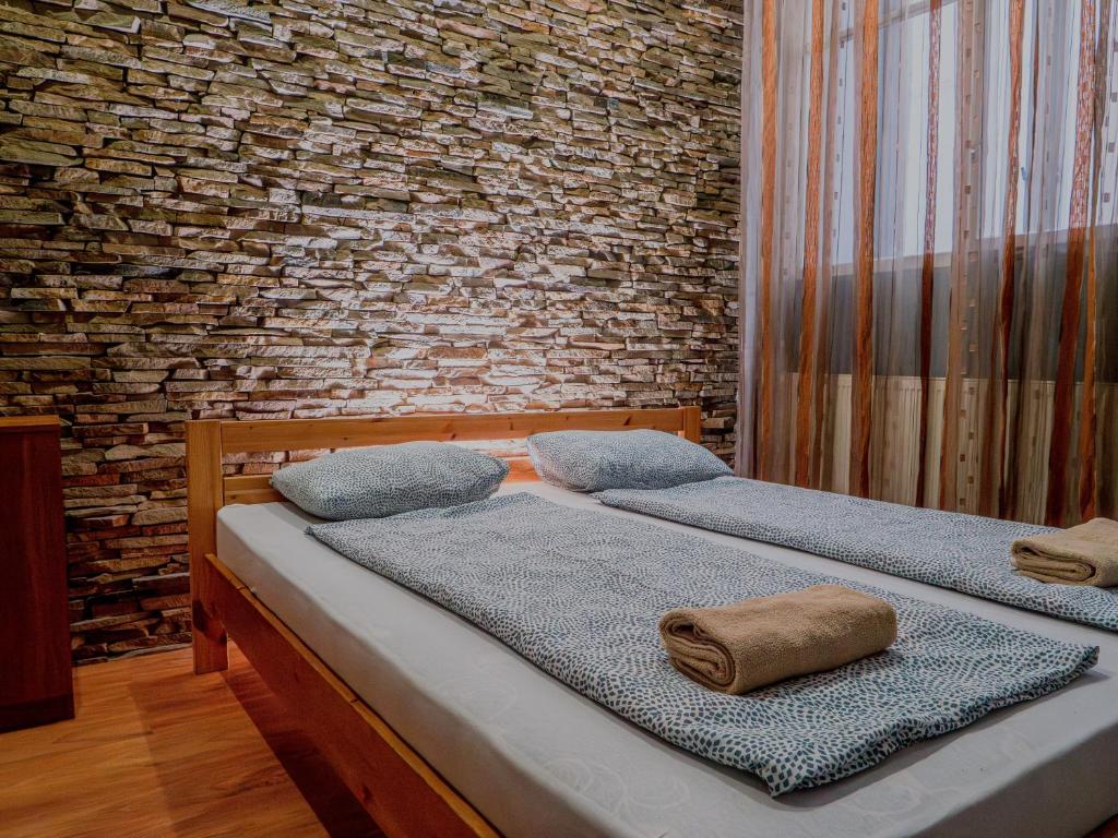 布达佩斯迪普旅舍的砖墙客房中的两张单人床