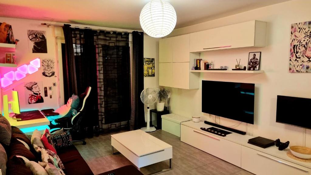 诺伊斯·勒·格兰德Appartement deluxe ac 1 chambre proche Paris Disney 20min rerA ou A4的带沙发和电视的客厅