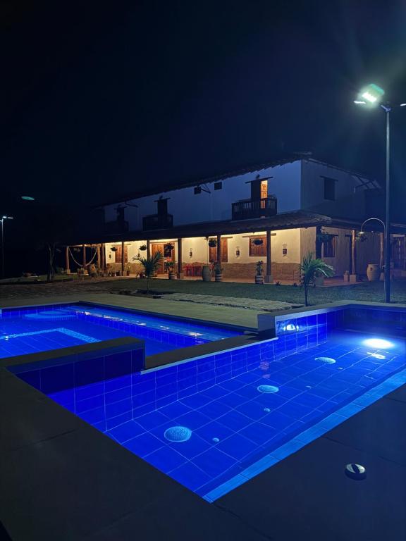 巴里查拉Hotel Palais Barichara的夜晚的游泳池,灯光蓝色