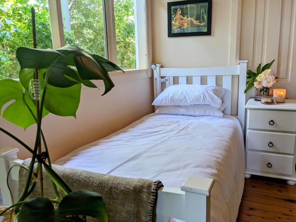 格里菲斯Paris's Place的卧室配有白色的床和植物