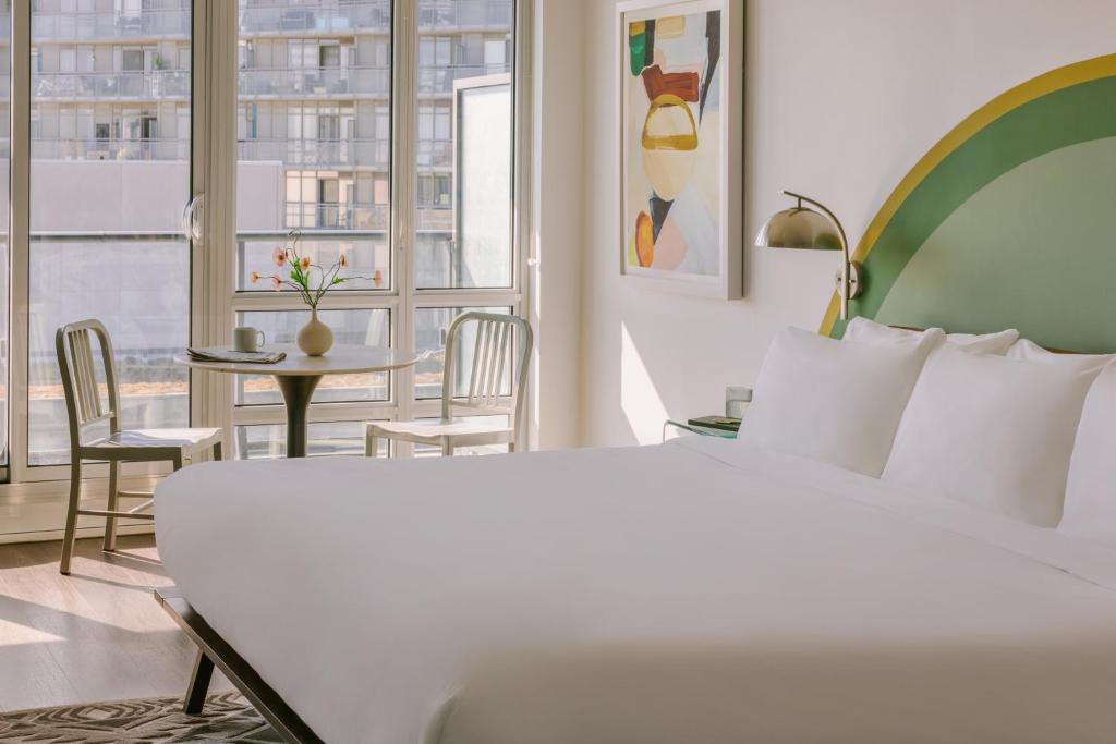 多伦多Sonder at The Liberty的酒店客房,配有一张床和一张桌子及椅子