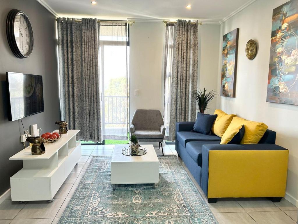 约翰内斯堡Lilly's Gold的客厅配有蓝色的沙发和黄色的椅子