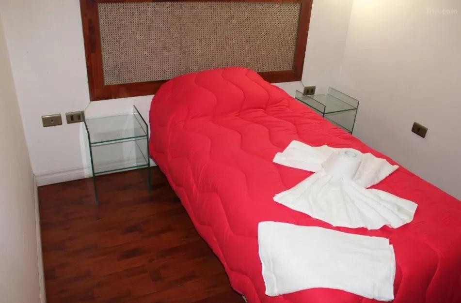 圣地亚哥Bitton Hotel Boutique的一张红色的沙发,位于带两个玻璃桌的房间