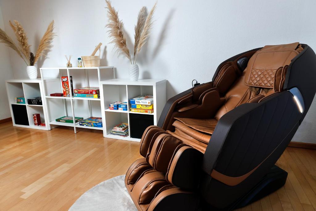 法伦达尔Vallhouse - Massage, Sauna, Darts, Switch & mehr的客厅里带架子的皮革躺椅