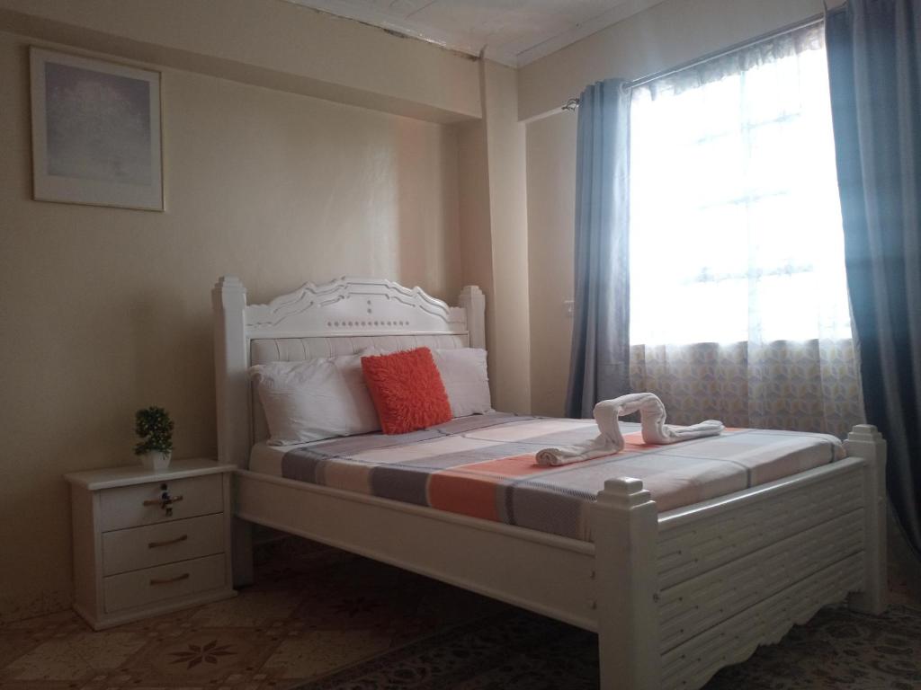 尼耶利MT. KENYA PALACE的卧室配有白色的床和窗户。