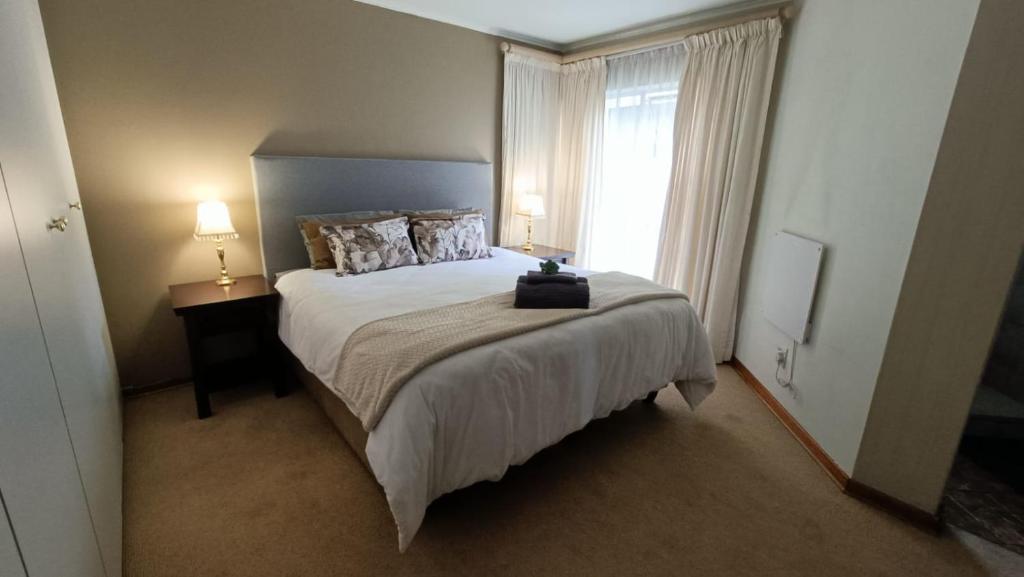 比勒陀利亚741 Tetra Self Catering Accommodation的一间卧室设有一张大床和一个窗户。