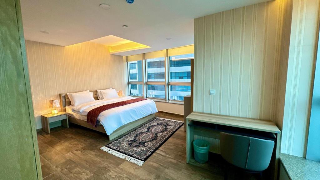 伊斯兰堡Centaurus Apartment City View One Bed的一间卧室设有一张床、一台电视和一个窗口。