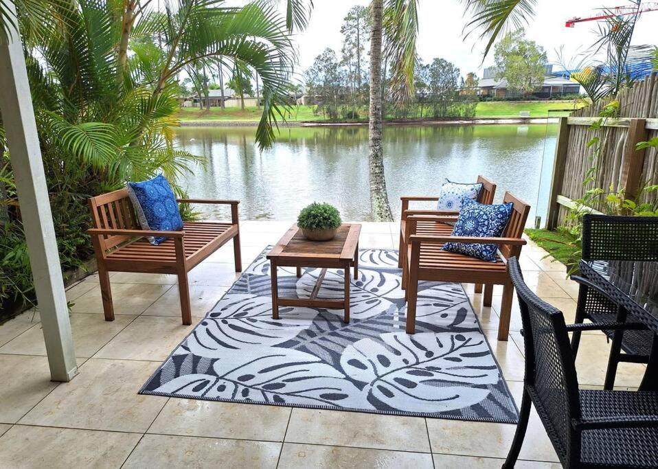 黄金海岸Isle of Palms 31的一个带三把椅子和一张桌子的庭院和一个池塘