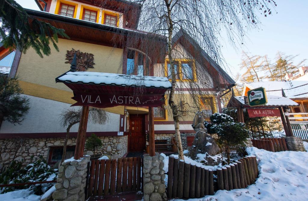 斯塔拉·里斯拉Wellness Vila Astra的雪中标有标志的建筑物