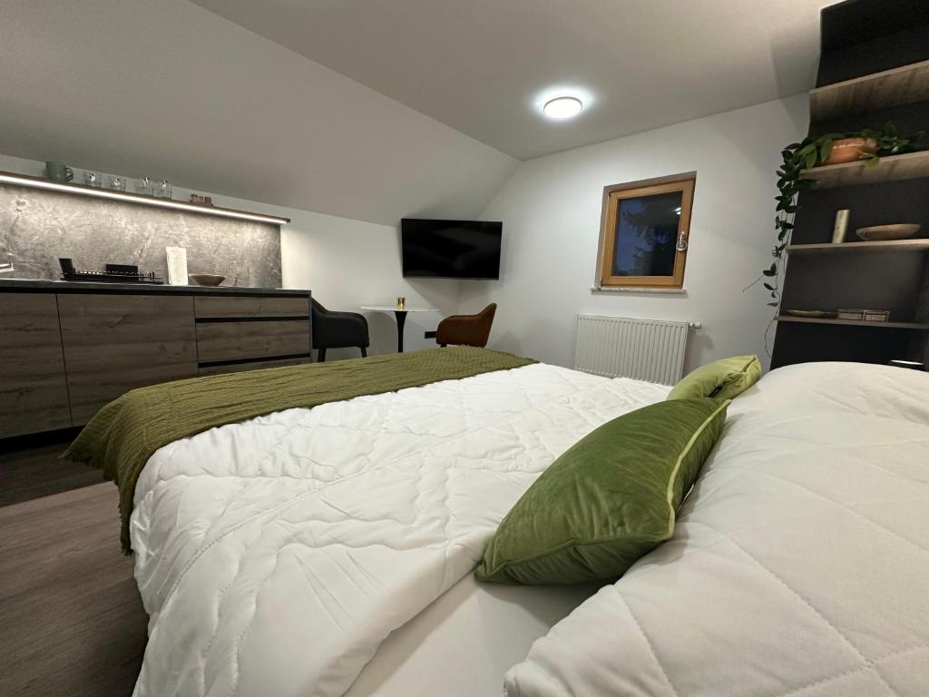 波希基斯卡贝拉4 Elements Resort Bled的卧室配有带绿色枕头的大型白色床