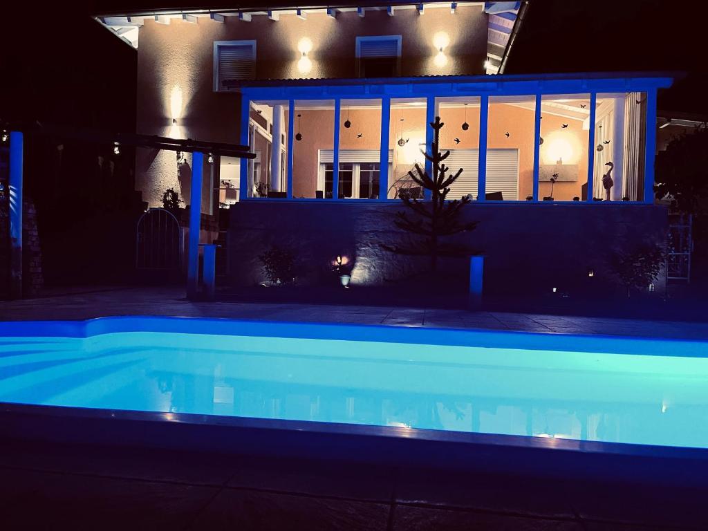 Aldersbach5 Sterne Centurion Ferienhaus Villa 2 Pools 86 Zoll TV的一座晚上设有游泳池的房子