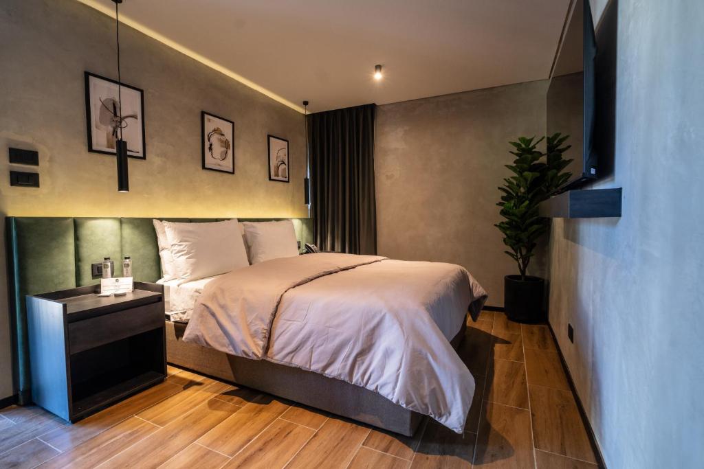 瓜达拉哈拉ALCALÀ EXPO的一间卧室配有一张床和一个种植了植物的床头柜