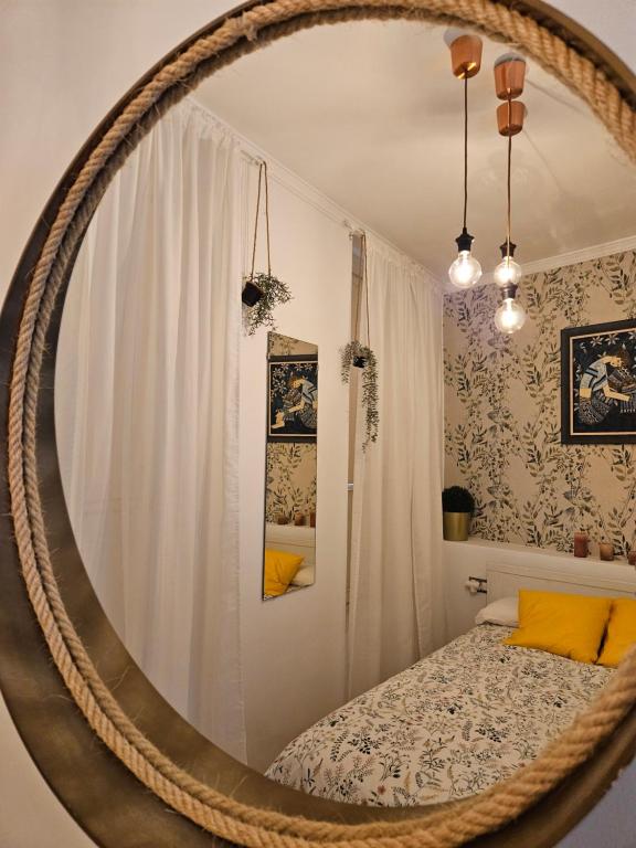 加的斯Paraíso Malecón de Cádiz的一张圆镜子,位于带床的房间