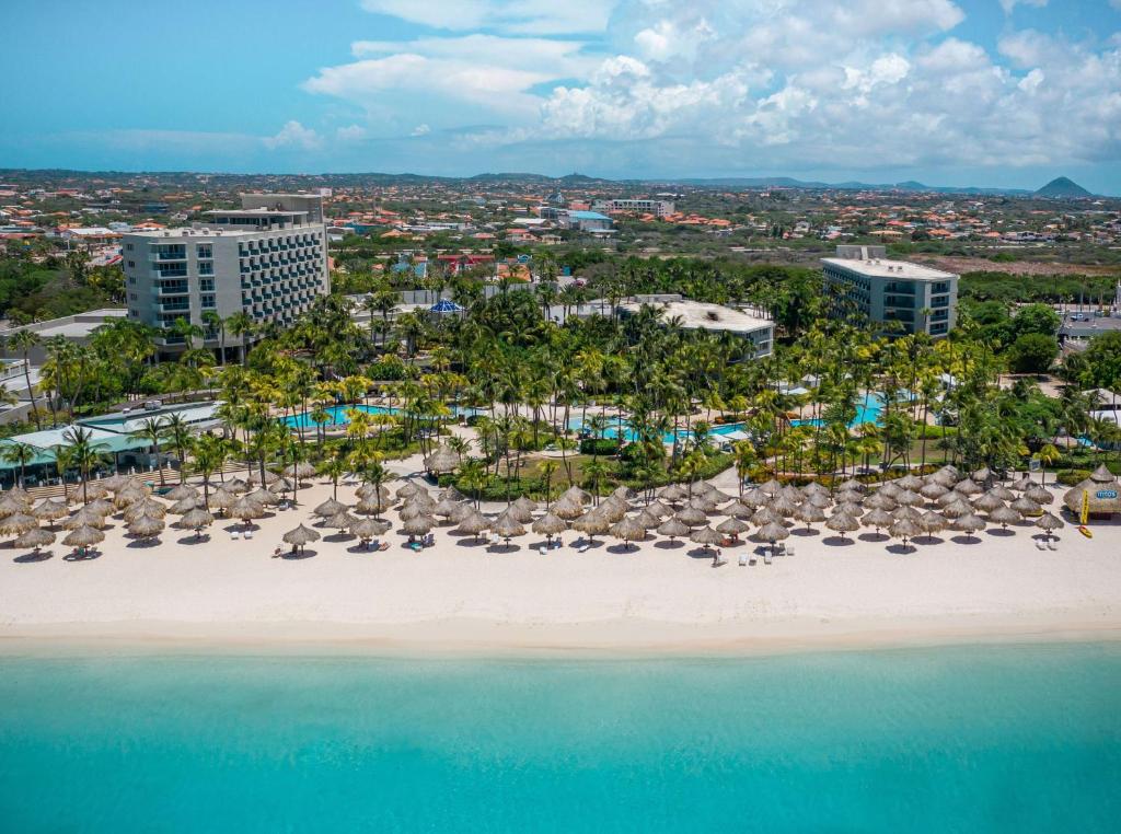 棕榈滩希尔顿阿鲁巴加勒比赌场度假酒店的享有海滩的空中景致,配有椅子和遮阳伞
