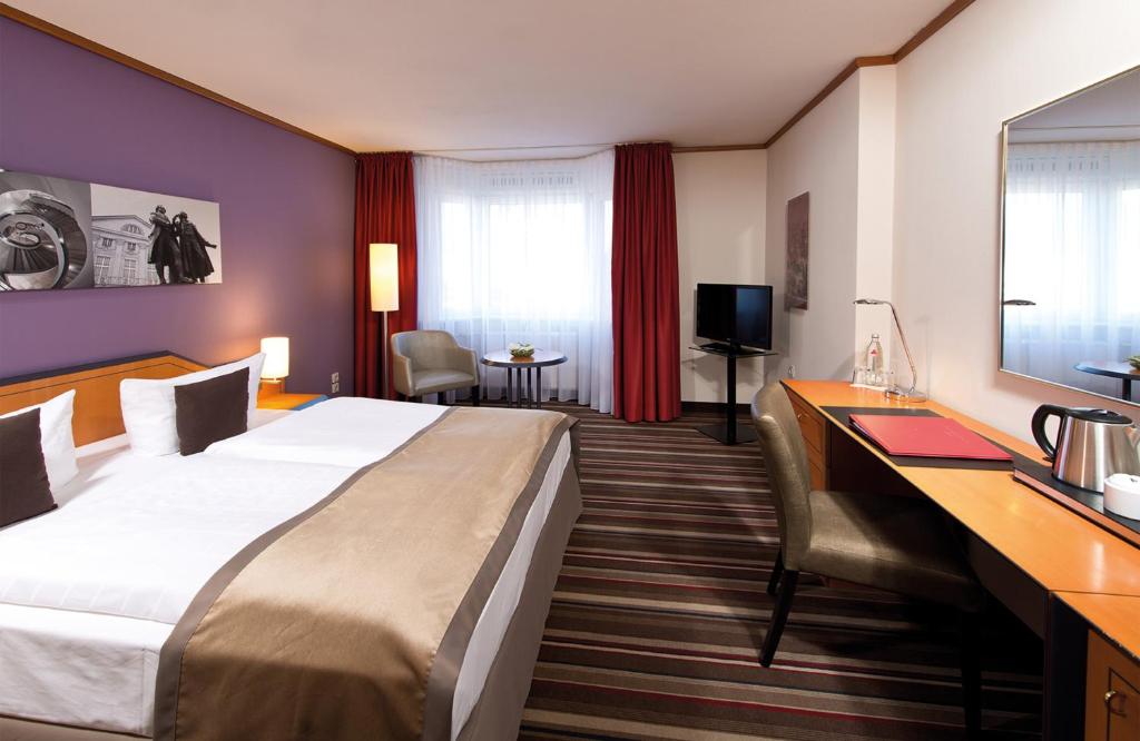 魏玛魏玛莱昂纳多酒店的酒店客房设有一张大床和一张书桌。