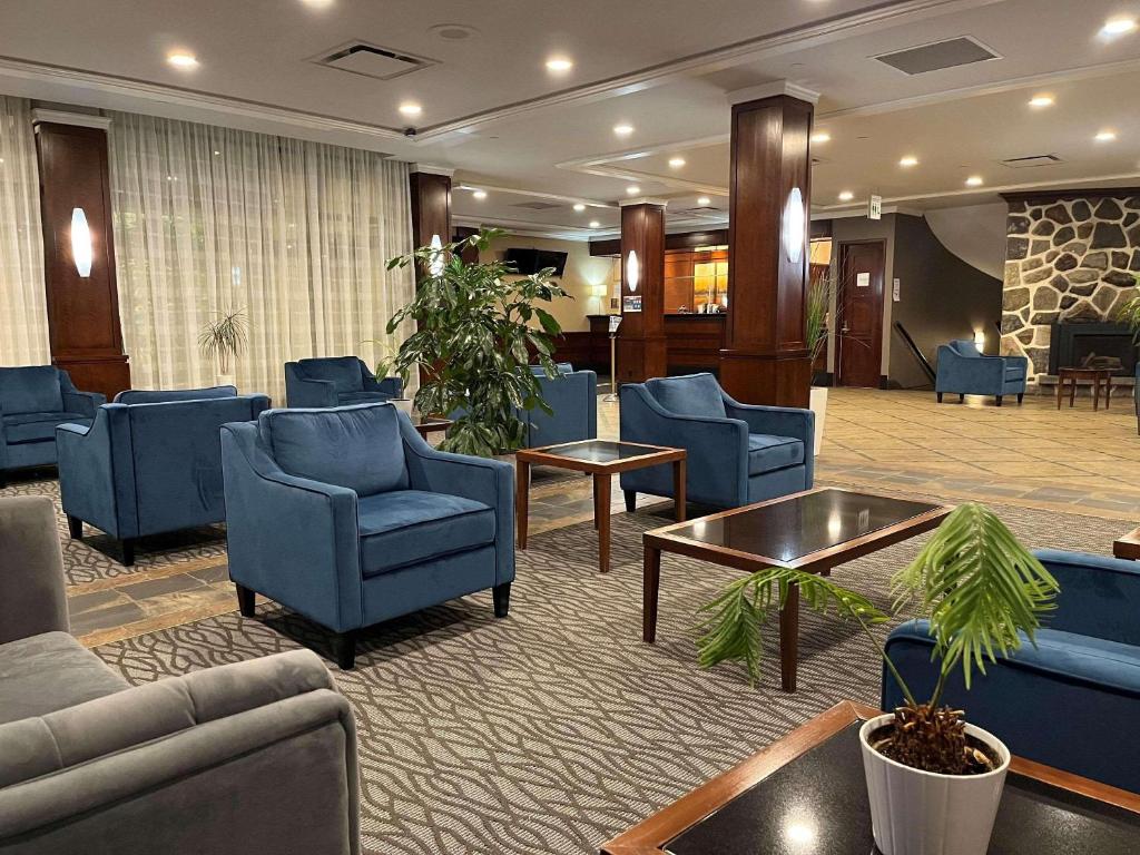 Ville Saint LaurentRadisson Hotel Montreal Airport的酒店大堂设有蓝色椅子和候机室