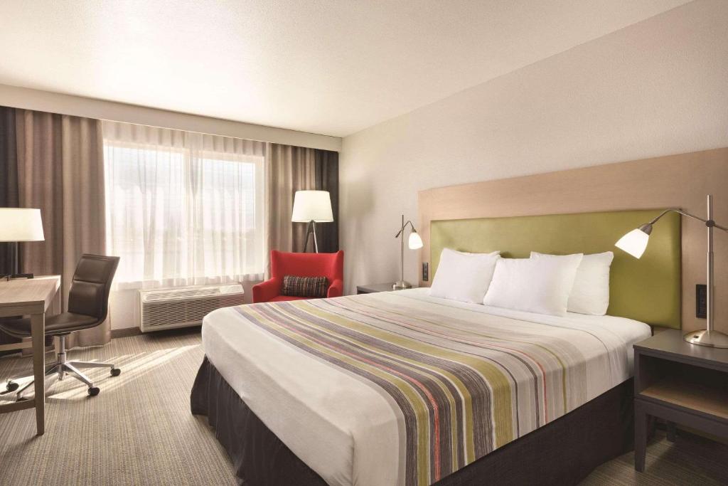 弗雷斯诺卡尔森弗雷斯诺北江山旅馆及套房酒店的酒店客房设有一张大床和一张书桌。