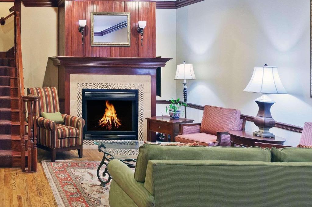塔尔萨塔尔萨机场Country Inn and Suites酒店的客厅设有壁炉、沙发和椅子