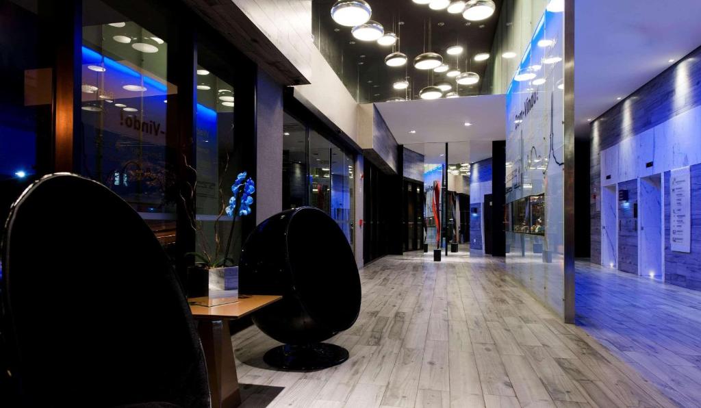 贝洛奥里藏特贝洛奥里藏特萨瓦斯丽笙酒店的商店的走廊,带桌椅