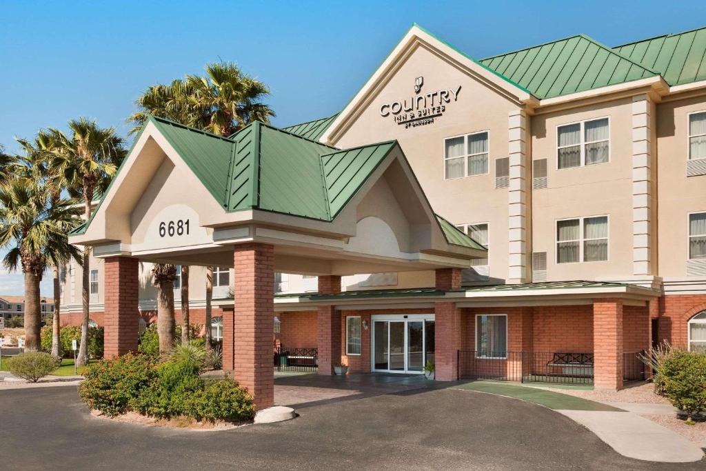 土桑卡尔森图森机场乡村套房酒店的酒店建筑拥有绿色屋顶和棕榈树