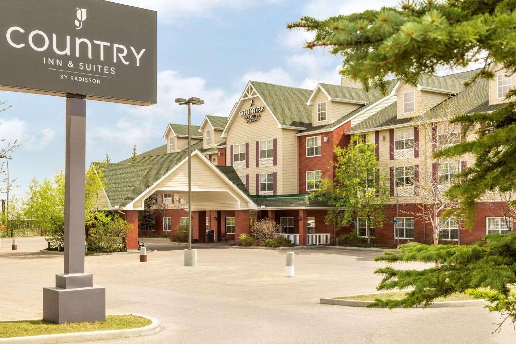 卡尔加里Country Inn & Suites by Radisson, Calgary-Northeast的建筑物前停车场的标志