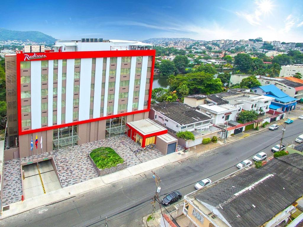 瓜亚基尔瓜亚基尔丽笙酒店的一条城市街道上的红色和白色大建筑