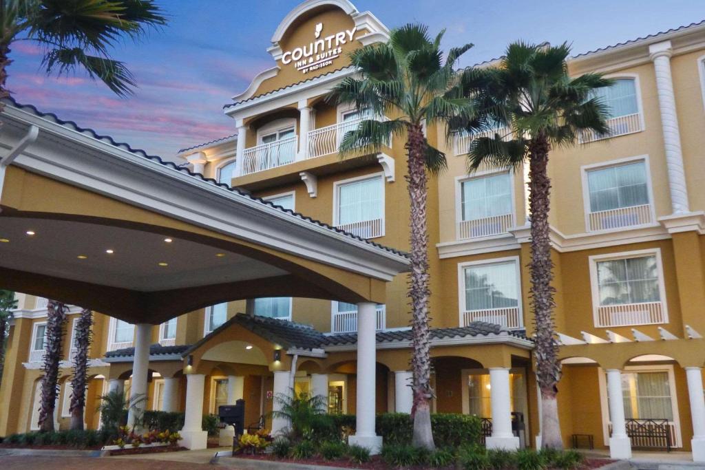 珀特奥兰治佛罗里达州橘子港代顿雷迪森乡村套房酒店 的前面有棕榈树的酒店