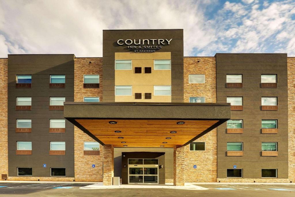 卡明Country Inn & Suites by Radisson, Cumming, GA的前面有标志的建筑