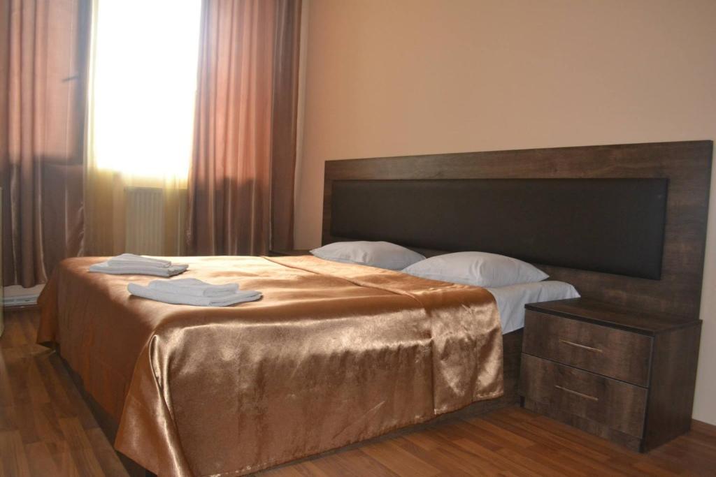 科布列季Hotel Solidarity的一间卧室配有一张大床和木制床头板