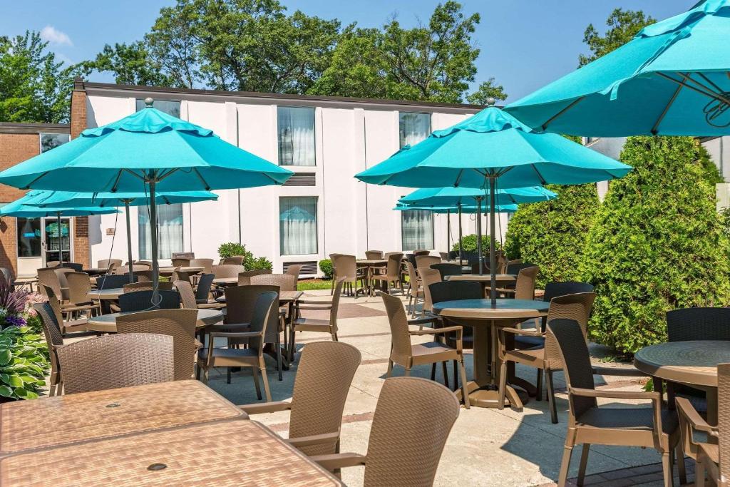 特拉弗斯城乡村旅馆及特拉弗斯城套房酒店的一组配有蓝色遮阳伞的桌椅