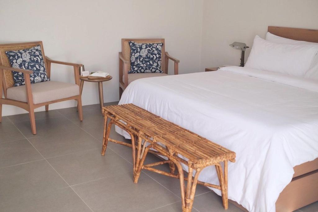 san juan la unionAginana Villas的卧室配有一张床和一张桌子及椅子