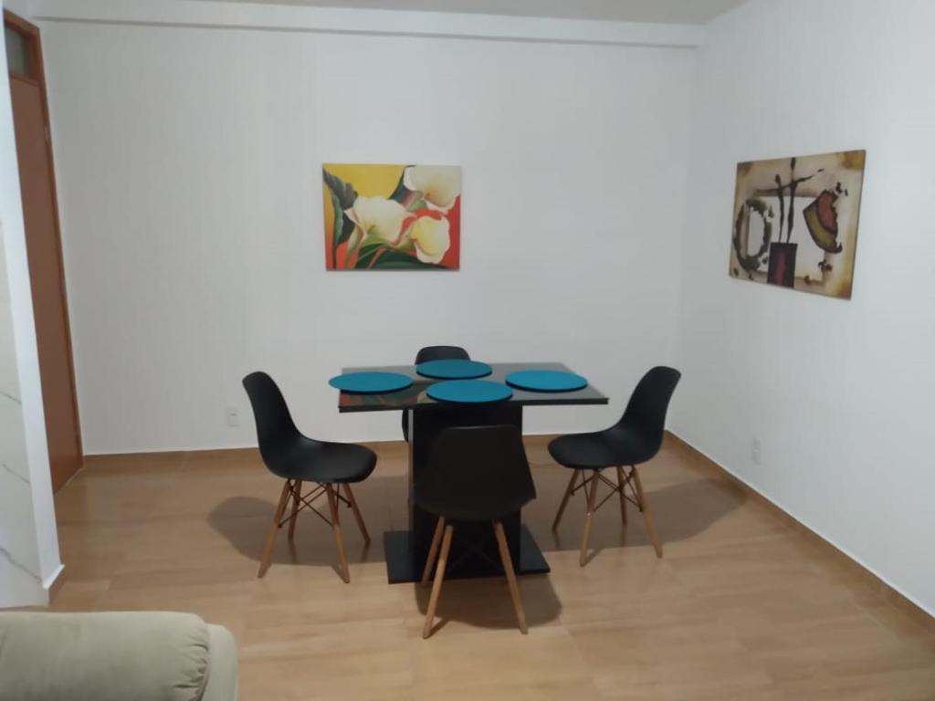 伊列乌斯Apartamento 3/4, 1 suíte Vog Atlântico的一间带桌子和四把椅子的用餐室