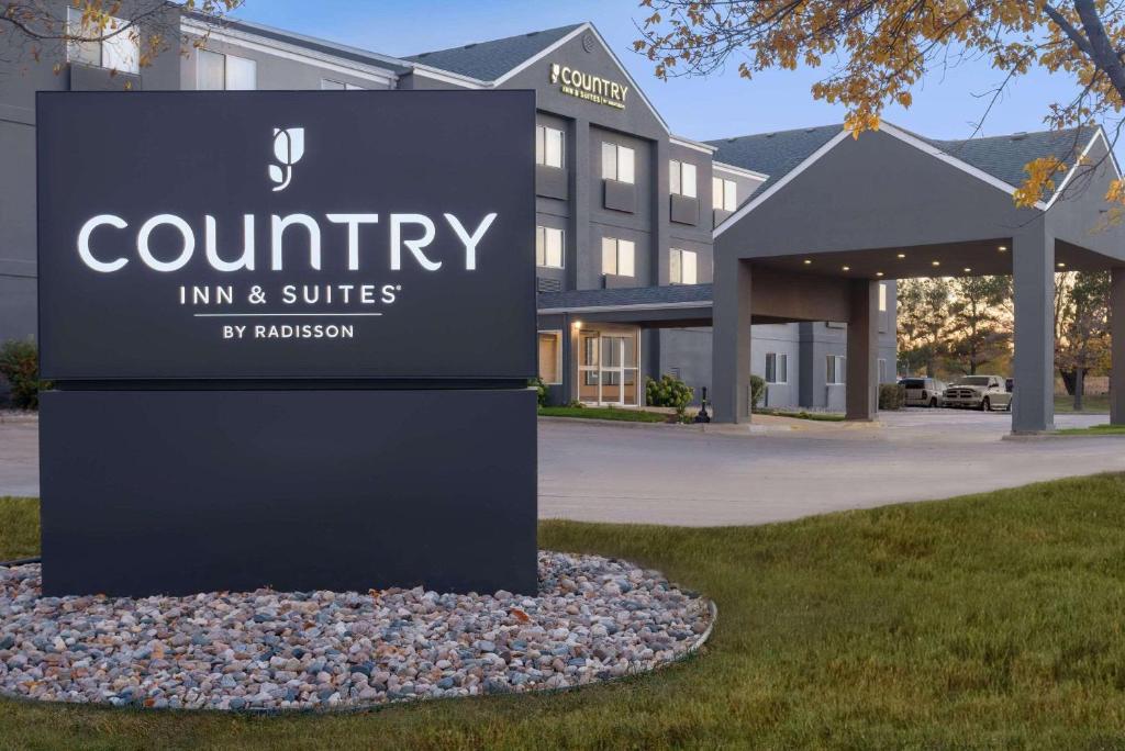 布鲁金斯Country Inn & Suites by Radisson, Brookings的一座建筑前的乡村旅馆和套房的标志