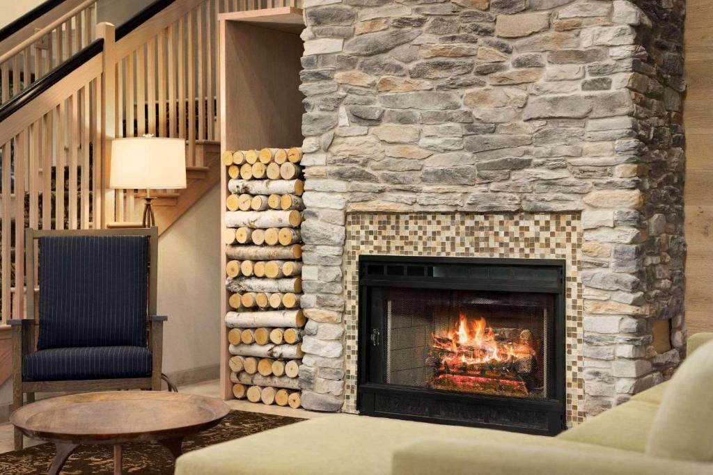 威廉斯堡威廉斯堡乡村酒店及套房的客厅设有石头壁炉、沙发和桌子
