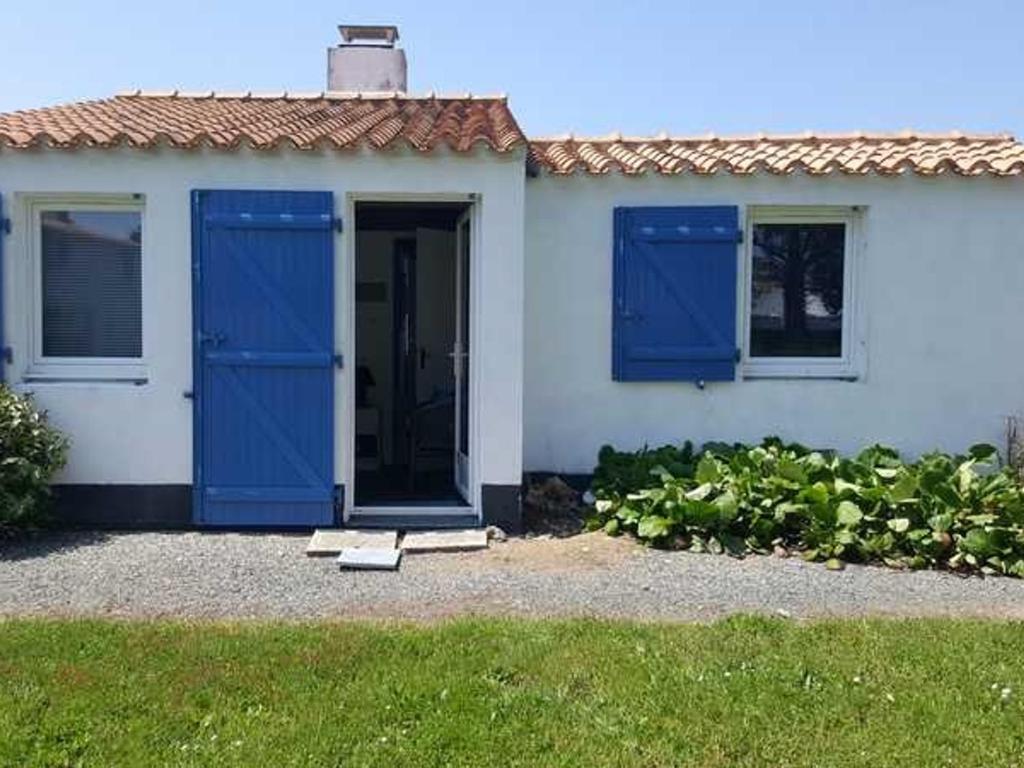 滨海布雷蒂尼奥勒Maison Bretignolles-sur-Mer, 3 pièces, 4 personnes - FR-1-231-300的白色的房子,设有蓝色的门和窗户