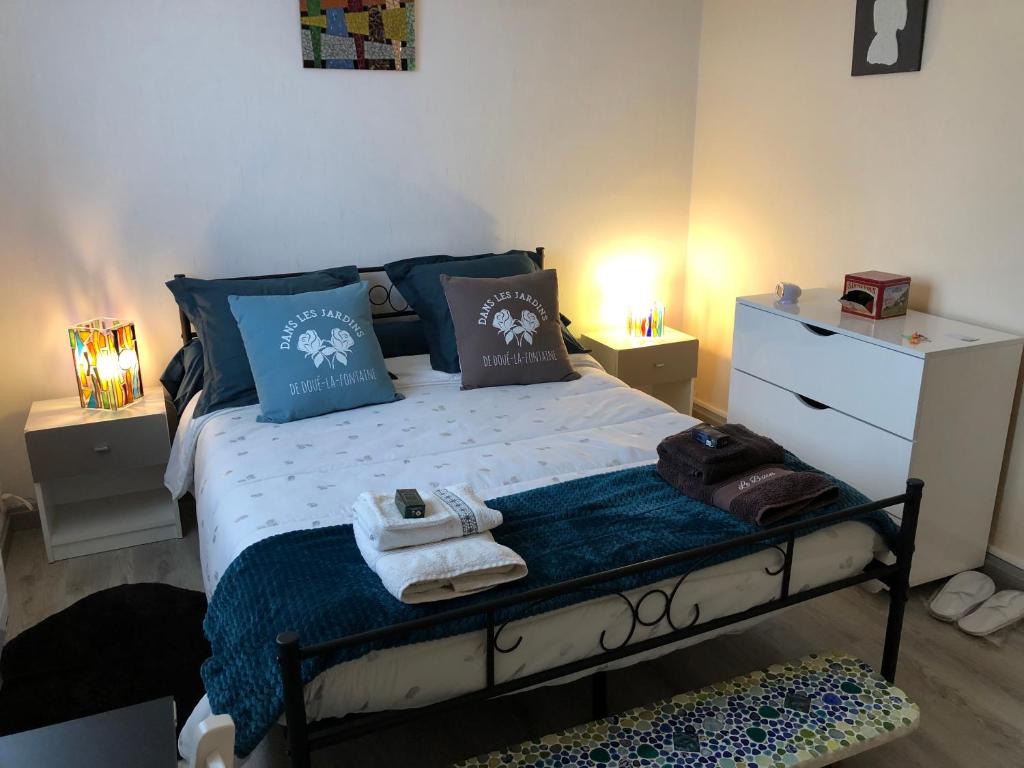 杜埃拉丰坦« Chez Annie »的一间卧室配有一张带蓝色枕头和毛巾的床。