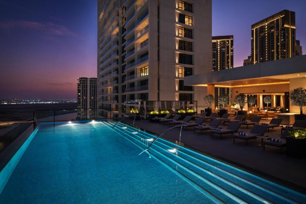 迪拜云溪港皇宫酒店的夜间在建筑物屋顶上的游泳池