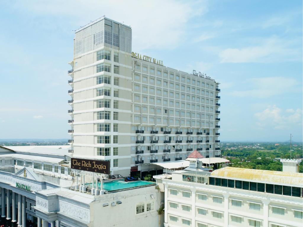 日惹The Rich Jogja Hotel的前面有标志的高大的白色建筑