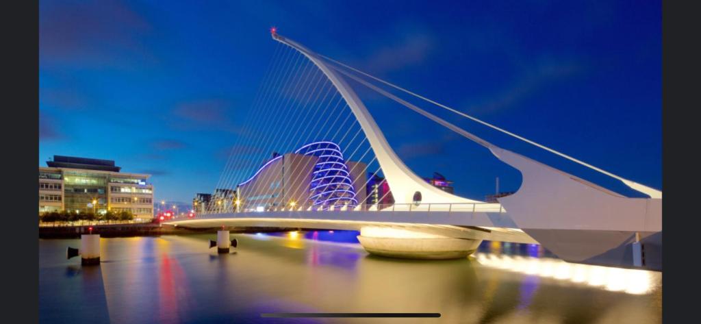 都柏林Modern Dublin City Centre的一座水面上的桥梁,一座建筑的背景