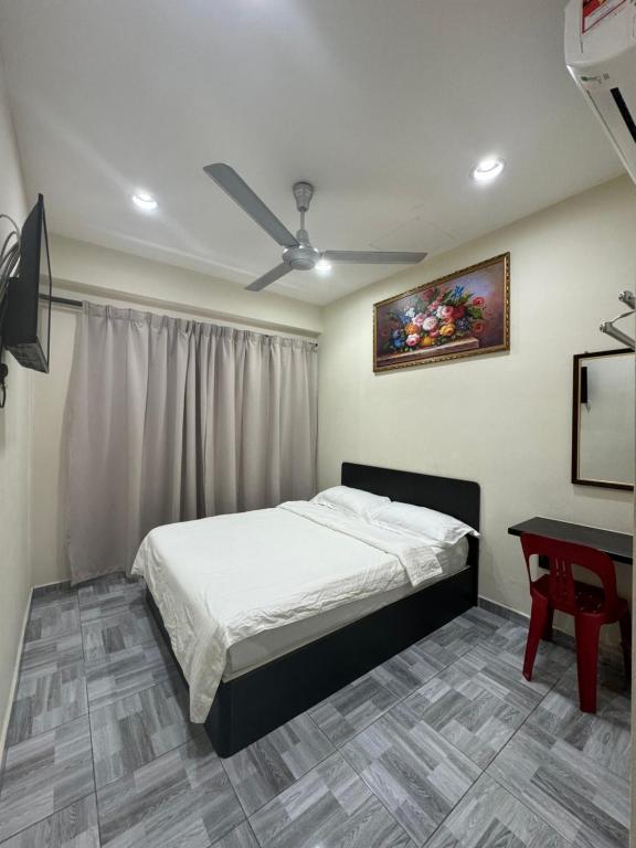 和丰西子楼 CZI Budget Hotel Sungai Siput的一间卧室配有一张床、一张桌子和吊扇