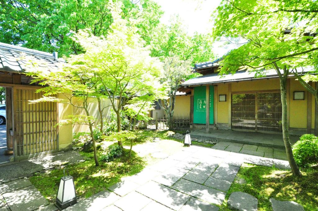 新发田市Ryokan Imai的坐在房子前面的猫