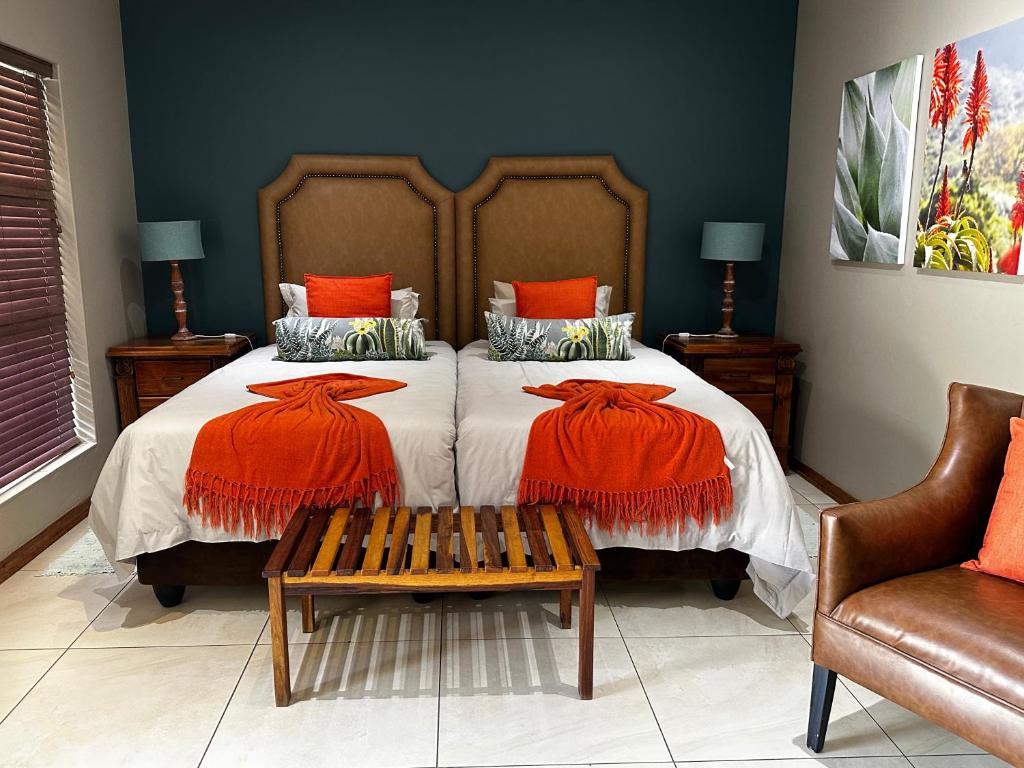 JwanengMeyers Guesthouse的一间卧室配有一张带橙色枕头的大床