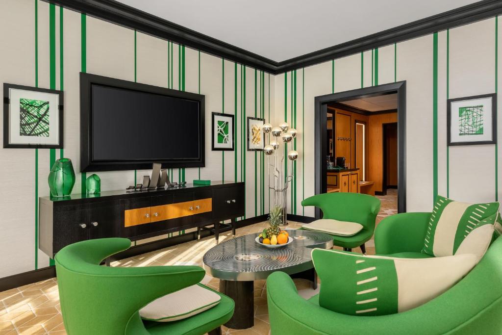 巴库Dinamo Hotel Baku的客厅配有绿色椅子和电视