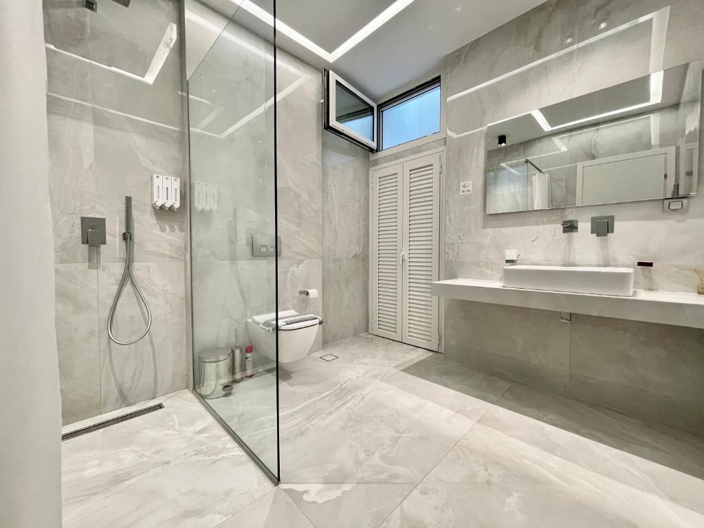 卡尼奥提Family villa SoFia 4 bedrooms的带淋浴、卫生间和盥洗盆的浴室