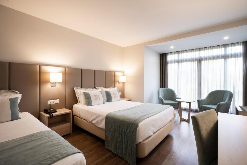 法蒂玛法蒂玛酒店的酒店客房,配有两张床和两把椅子
