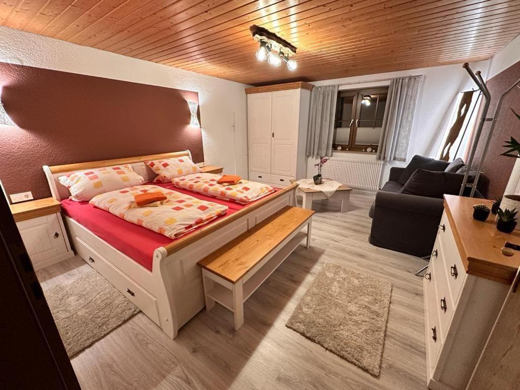 OberkirnachFerienhof-Gerda-Ferienwohnung-Schwalbennest的一间卧室设有一张床和一间客厅。