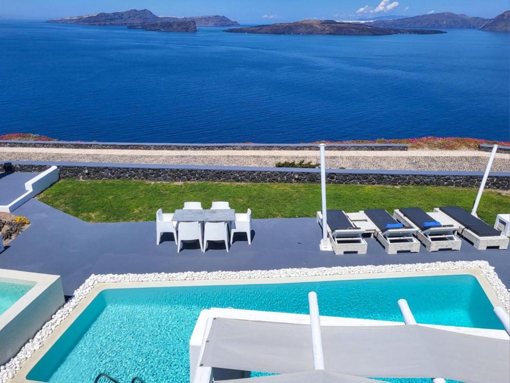 阿克罗蒂里圣托里尼公主总统套房酒店的一个带桌椅的海洋游泳池